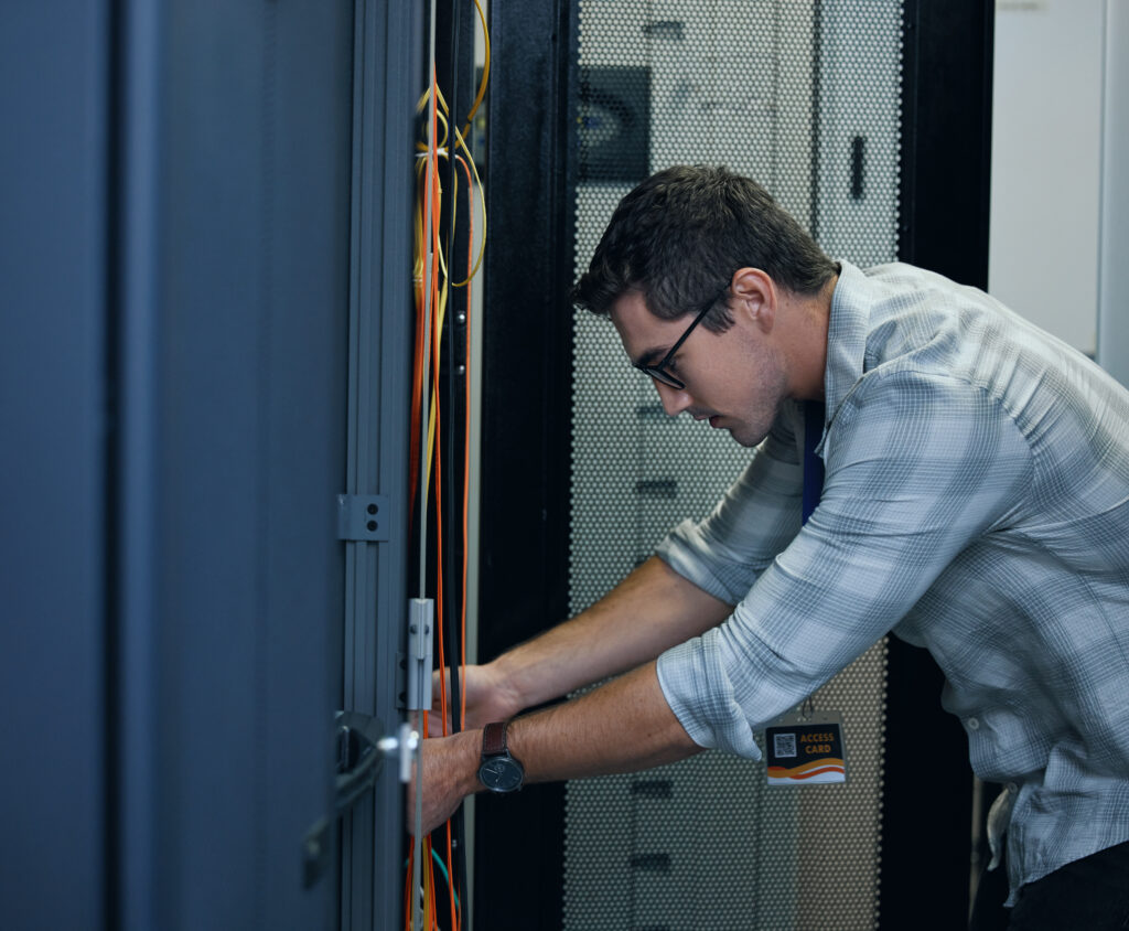 IT-Techniker überprüft Netzwerkkabel im Serverschrank